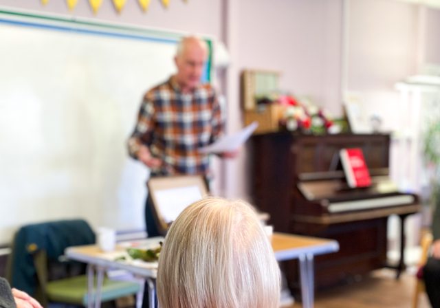 Photo of author Ken Cockburn talking with the back of a persons head in the foreground
