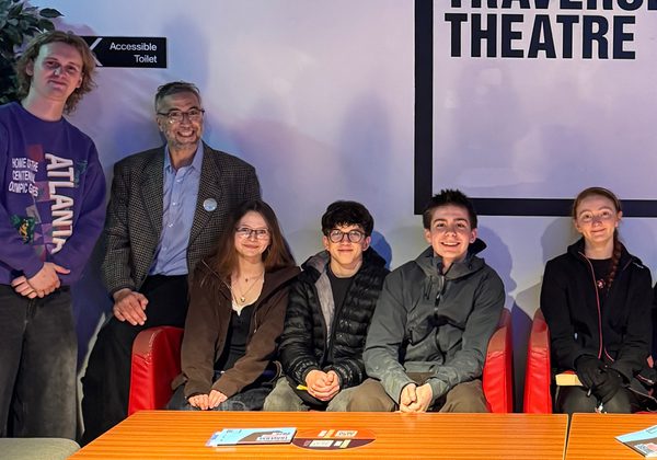 Young writers from the Citizens Collective seated posing for photo with author Ryan van Winkle.