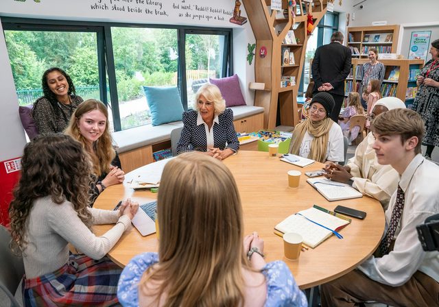 Young writers part of citizen collective sitting round table with Queen Camilla at Ratho library