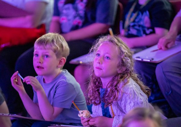 Two children watching an event at the Book Festival