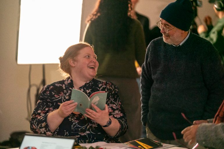 Two people flipping through a book