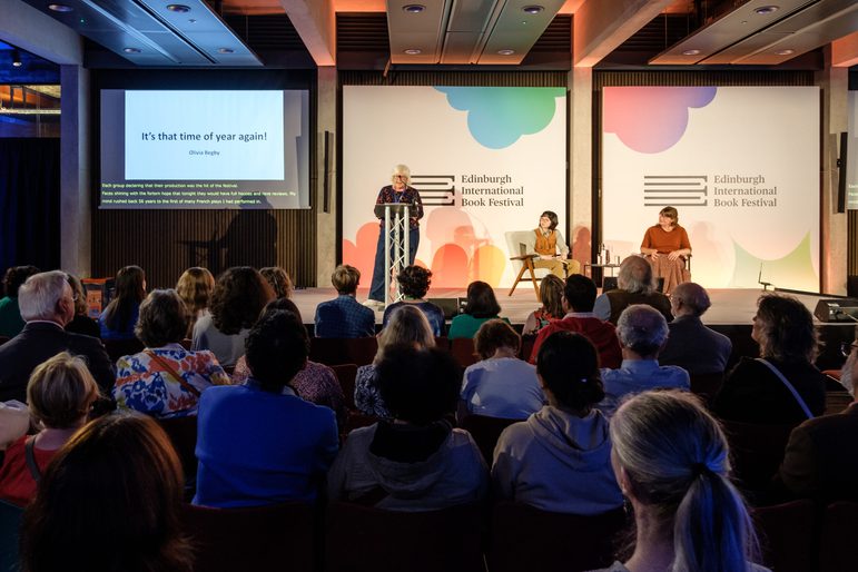 Large group watching speakers on stage