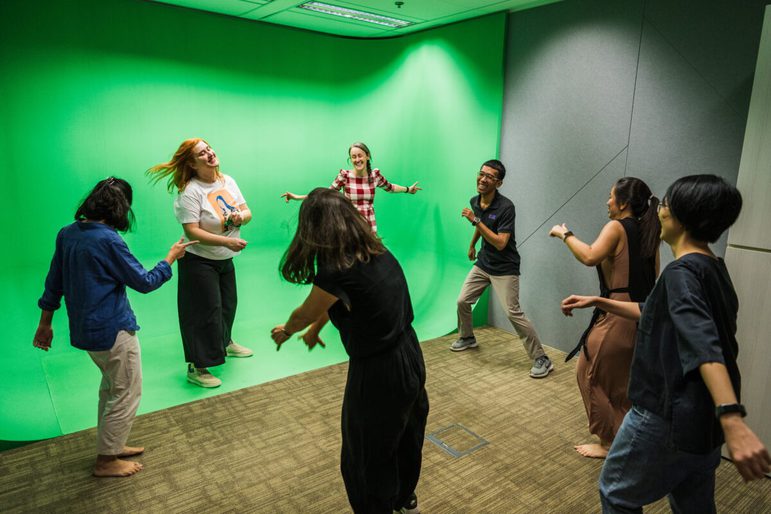 Group of people interacting with a green screen