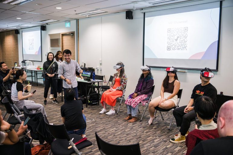 Group of people sitting on chairs with virtual/augmented reality headsets on