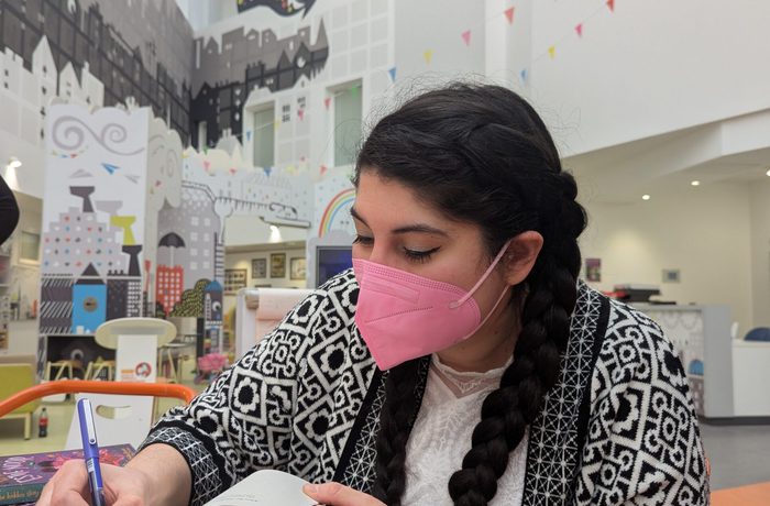 Author Nadine Aisha Jassat signing a book at Edinburgh Sick Kids