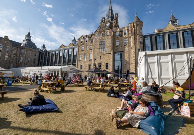 People relaxing in Book Festival courtyard on a sunny day