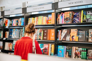 Person in red shirt browsing books in the Book Festival bookshop