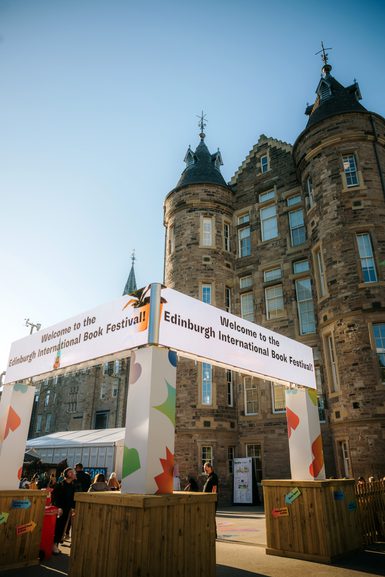 Image of Book Festival entrance with Edinburgh Futures Institute building in the background with bright blue sky.