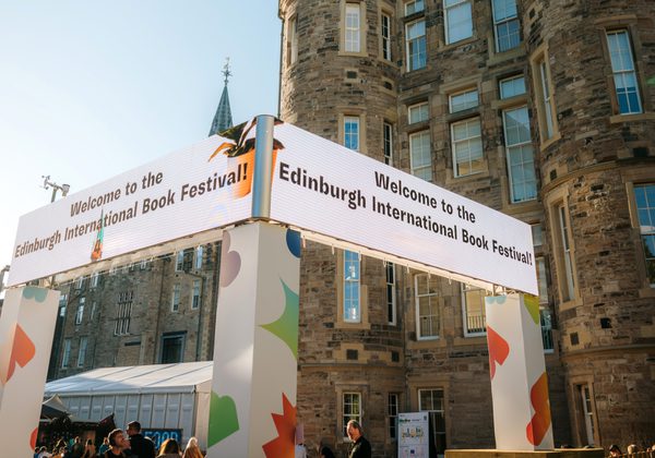 Image of Book Festival entrance with Edinburgh Futures Institute building in the background with bright blue sky.