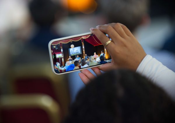 Person holding up phone taking photo of event in Spiegeltent