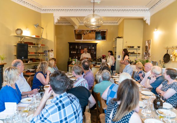 People sitting at tables in small restaurant space at Elliott's Studio