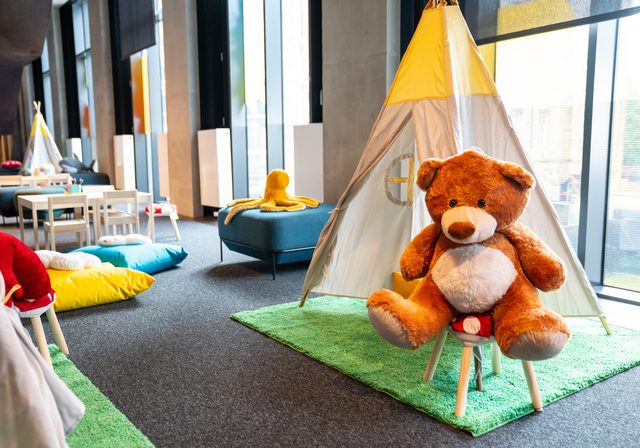 A large teddy bear, a small play tent, and other toys
