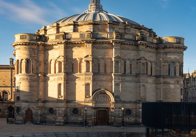 Photo of outside of McEwan Hall and Bristo Square with blue sky