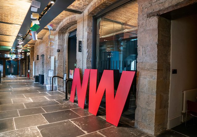 Signage for Book Festival venue NW in corridor that features large NW letters in a corridor